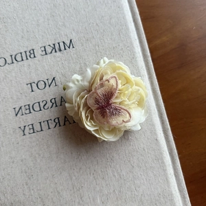 Elegant cream white fabric flower hair clip with detailed butterfly embroidery detail