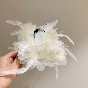 Macro shot of large white feather bow hair claw with translucent layered mesh petals
