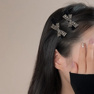 Sparkling silver rhinestone bow hair clips with black velvet on a female model