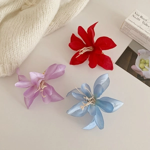 Gros plan détaillé de pinces à cheveux magnolias en tissu rouge, bleu et violet