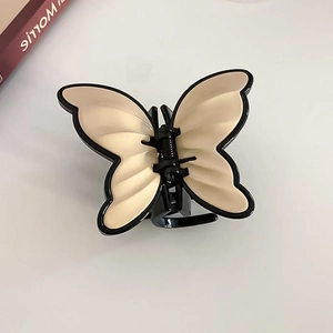 Detail of a vintage French butterfly hair claw clip with black and cream wing patterns