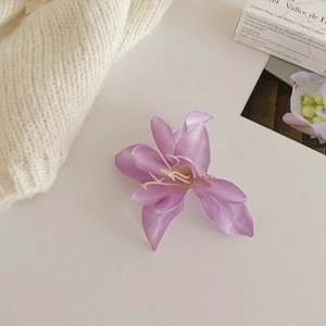 Vue détaillée de la pince à cheveux magnolia violette avec texture de soie fine
