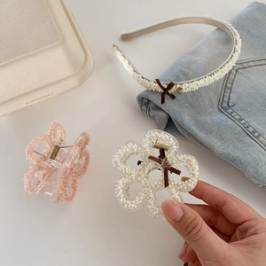 Detail of floral hair claws and headband with pearls, velvet bows and heart charms