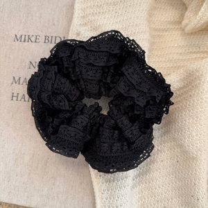 Detailed close-up of a premium black multi-layer lace scrunchie with elegant pleated fabric