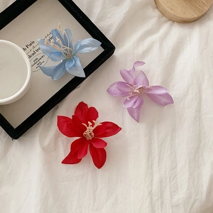 Détail de pinces à cheveux magnolia en tissu de soie rouge, violet et bleu