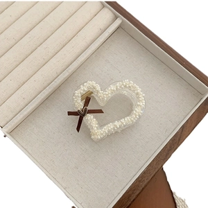 Elegant heart-shaped hair claw clip with white pearls and a delicate brown bow decoration