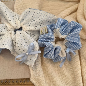 Gros plan de chouchous en dentelle blanche et carreaux bleus avec nœuds de perles