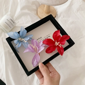 Détail de pinces à cheveux magnolia en soie faites à la main, tons bleu, violet et rouge