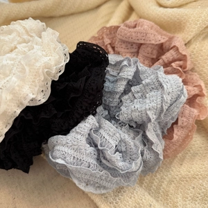 Detailed macro view of multi-layered lace scrunchies in white, black, blue, and pink colors