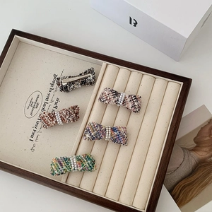 5-piece set of French style tweed bow hair clips with pearls on a wooden tray