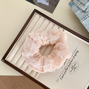 Dettaglio ravvicinato di un elastico in chiffon rosa pallido con frange di piume bianche