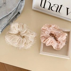 Dettaglio degli elastici scrunchie panna e rosa con bordi in piuma, stile coreano