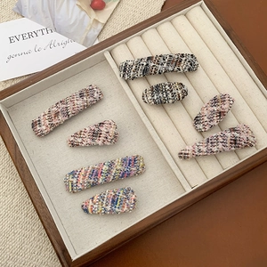 Close-up of colorful tweed fabric hair clips in rectangular and teardrop shapes