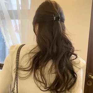 Elegante pinza per capelli nera con perle vista posteriore su capelli mossi