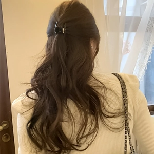 Elegante molletta per capelli nera con perle mostrata sui capelli di una modella