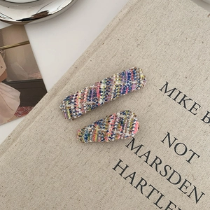 Macro shot of colorful tweed fabric hair clips with vintage knit texture and patterns