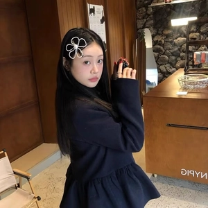 Elegant large pearl flower hair clip for women worn on hair by a model in a cafe