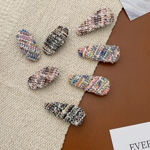 Close-up of colorful tweed fabric hair clips in oval and waterdrop shapes for women