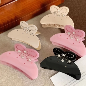Détail des pinces à cheveux papillon en acétate avec strass en noir rose et crème