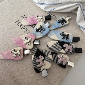 Detailed view of polka dot puppy fabric hair clips in various colors on burlap fabric