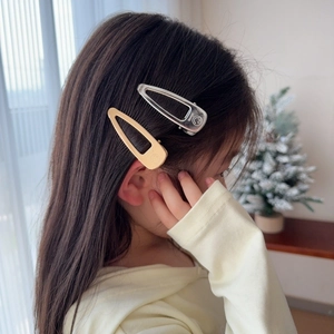 Golden and silver smile water drop hair clips worn by a young child model