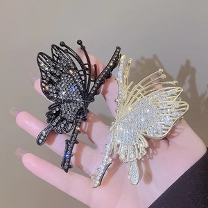 Close-up of hollow butterfly hair claws with shiny rhinestones in black and silver