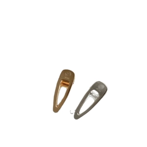 Polished gold and silver metal smile face duckbill hair clips set on white background