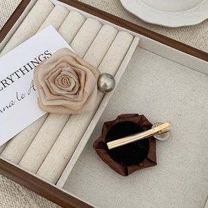 Detailed view of handmade fabric rose hair clips with vintage champagne petals and pearls