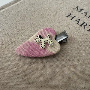 Close-up of pink woven heart hair clip with a cute Dalmatian puppy embellishment