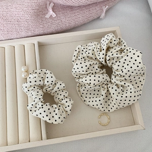 Gros plan de chouchous à pois sur un plateau à bijoux avec accessoires élégants