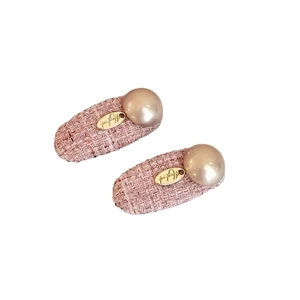 Pink tweed hair clips with faux pearls and gold oval charms in a 45-degree view