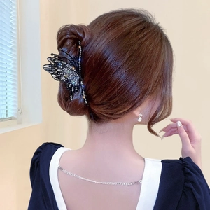 Elegant black hollow butterfly hair claw clip with rhinestones shown on a model