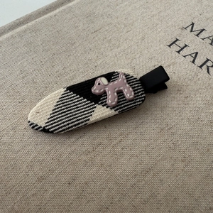 Close-up of fabric-wrapped polka dot hair clip with a purple dog resin charm