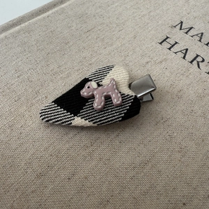 Detail of heart hair clip featuring polka dot pattern fabric and a pink puppy ornament
