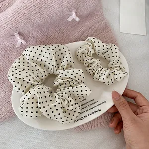 Vue détaillée de deux chouchous crème à pois de tailles différentes sur un plateau