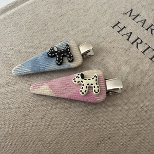 Detailed macro view of woven fabric hair clips with cute stitched dog patterns