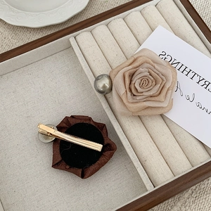 Elegant dried rose hair claw clips with faux pearl accents in a vintage wooden tray