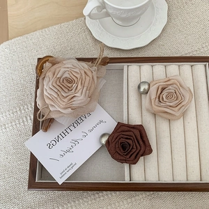 Elegant fabric rose hair claw clip set with pearl accents in warm brown and cream tones