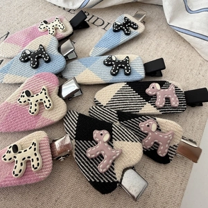 Detail of colorful knitted dog hair clips with checkered and striped fabric textures