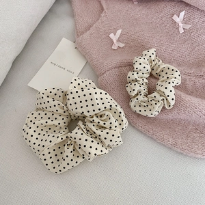 Lot de deux chouchous à pois de couleur crème sur un fond esthétique et doux
