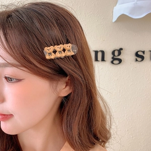 Detail view of sweet bear hair clip with three brown resin bears on a female model's side hair