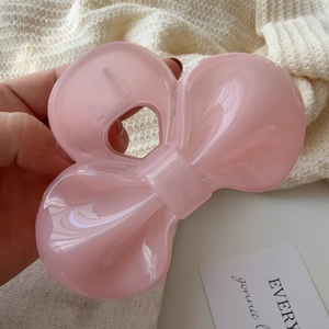Macro detail of a soft pink translucent bow hair claw clip for elegant styling