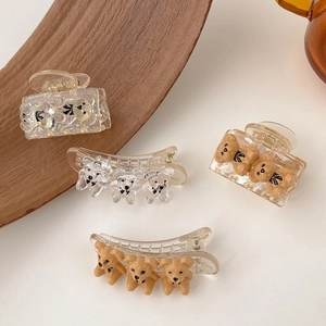 Detail of four cute bear hair clips including transparent glitter and brown matte styles