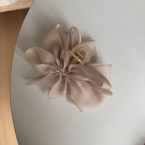Detail view of multi-layer chiffon bow hair claw with transparent resin clip