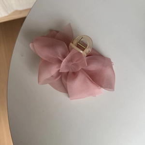 Macro detail of elegant pink chiffon flower hair claw with durable plastic grip