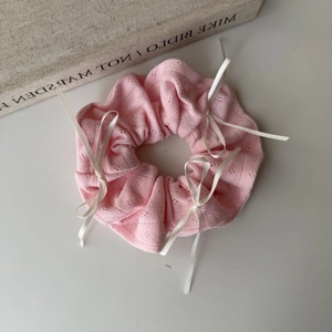 Pink knit scrunchie with white satin bows and elegant hollow point pattern for ponytail