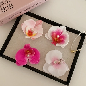 Détail de quatre pinces à cheveux orchidée dégradées avec des perles centrales élégantes