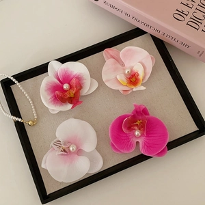 Lot de quatre barrettes orchidées avec perles sur un support de présentation