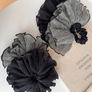 Détail de chouchous noir et pied-de-poule sur un livre pour accessoires de coiffure