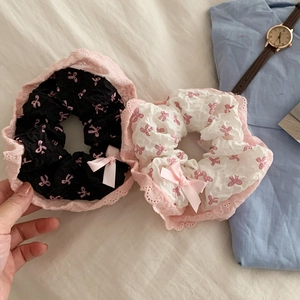 Gros plan détaillé des chouchous en dentelle à nœud rose en styles noir et blanc sur tissu